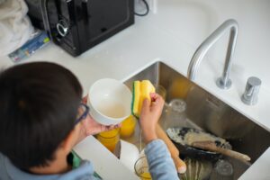 child cleaning sink