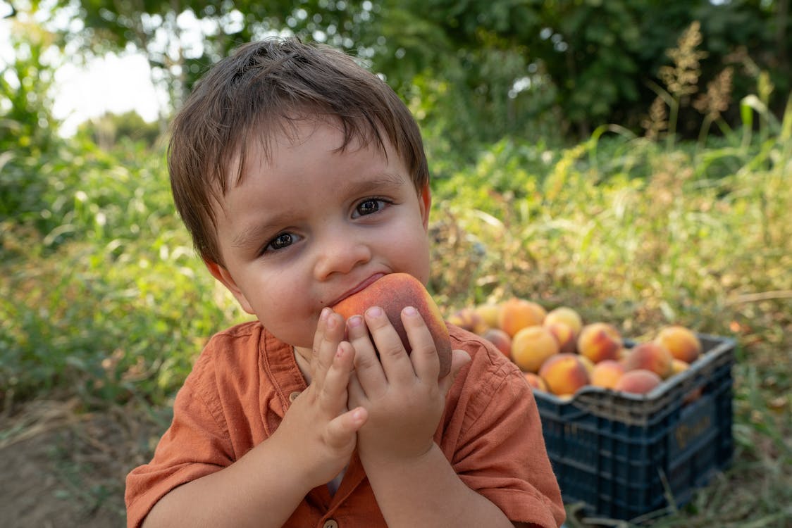 child eating peach