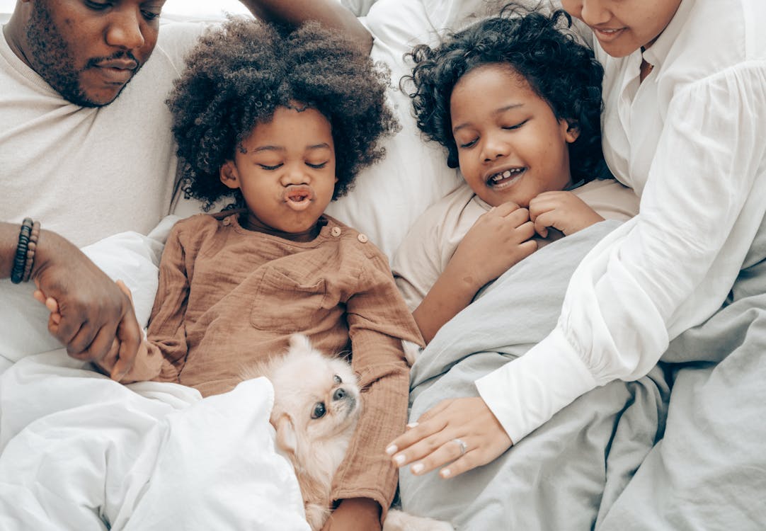 family in bed with a dog