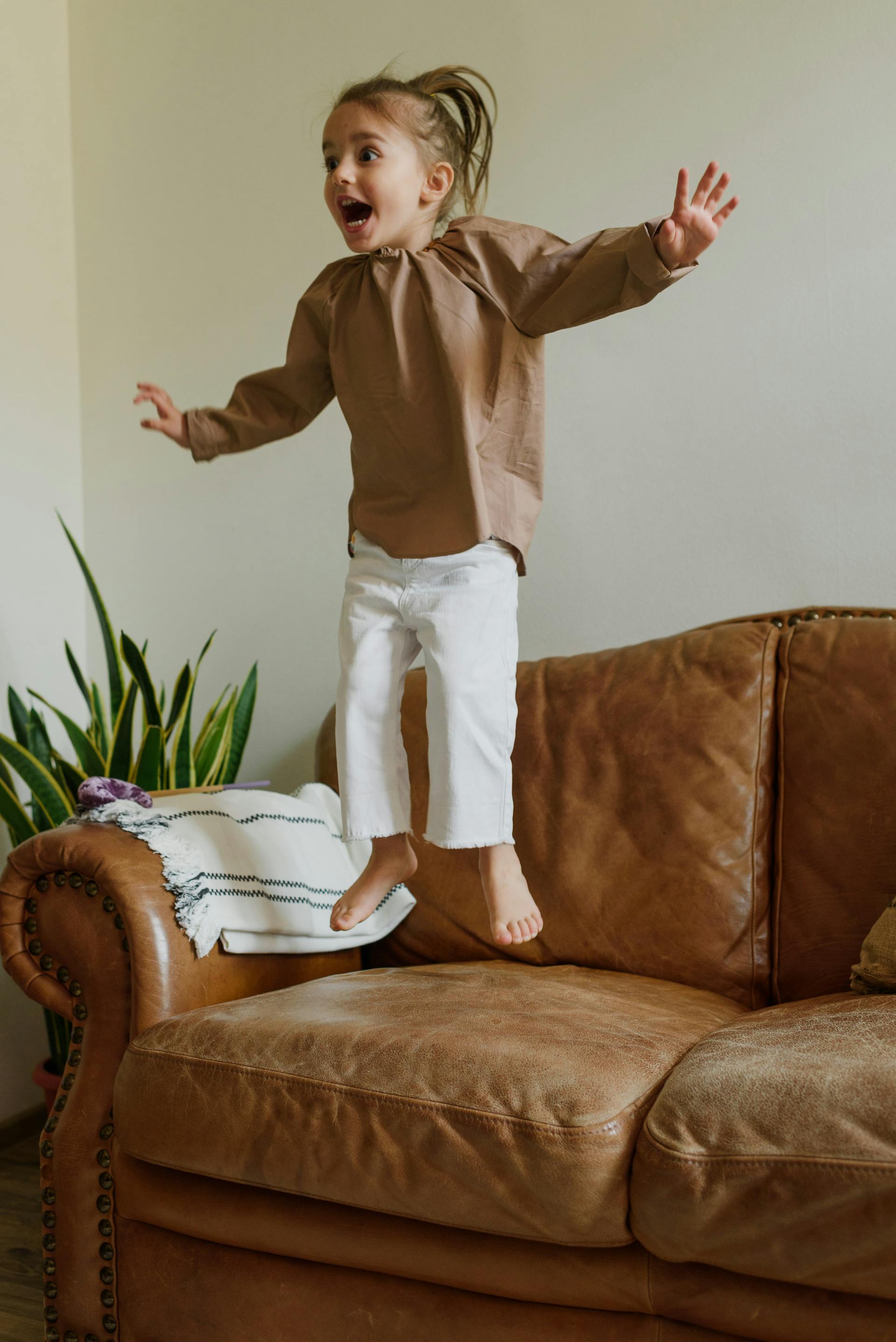 girl jumping on couch