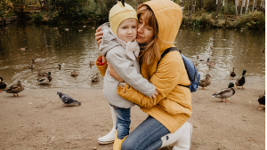 Mother hugging child outdoors to strengthen family relationship quality and well-being